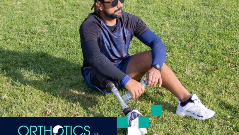 An amputee wearing prosthesis sitting on the grass
