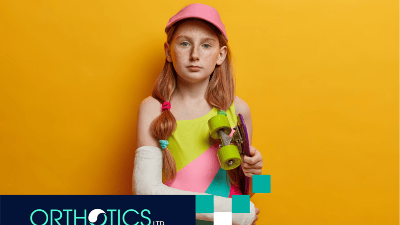 A kid wearing prosthetic holding a skateboard