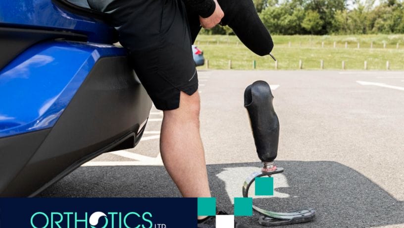 An amputee standing outdoors with his prosthetics